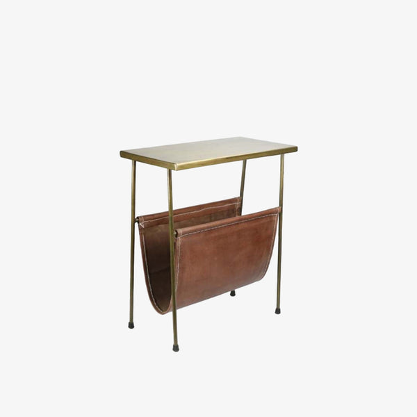 Rectangular brass side table with magazine rack leather storage below on a white background