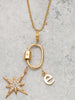 Scream Pretty brand carabiner charm necklace in gold on a stone background with charms