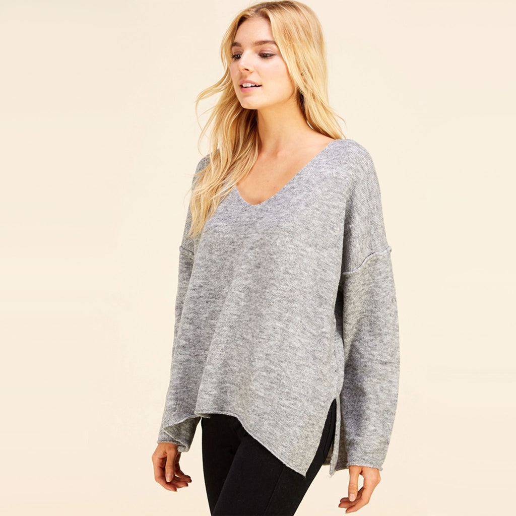 Blond Model wearing Pinch brand grey v neck loose fitting sweater with black pants