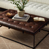 Living room with white sofa and Four hands brand Oxford rectangular coffee table with black iron frame frame and distressed brown leather top with books and vase