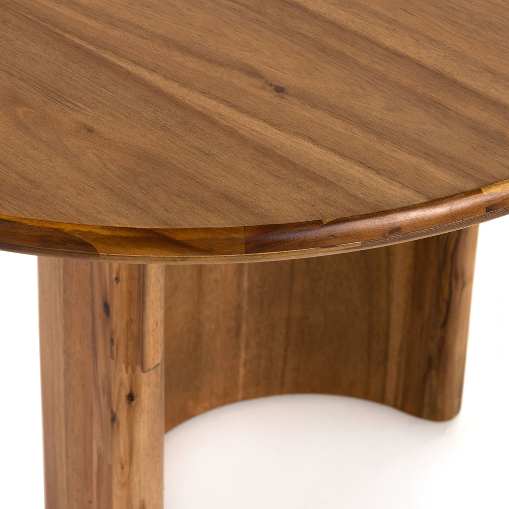 Close up of top on Light wood 'Paden' oval dining table by Four Hands Furniture with two legs to support thick top on a white background