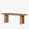 Light wood 'Paden' oval dining table by Four Hands Furniture with two legs to support thick top on a white background