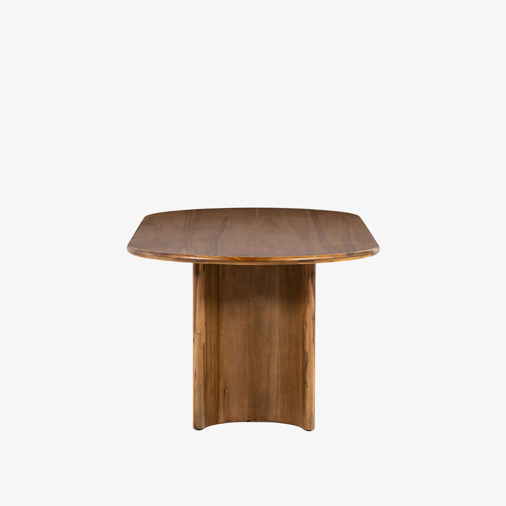 Light wood 'Paden' oval dining table by Four Hands Furniture with two legs to support thick top on a white background