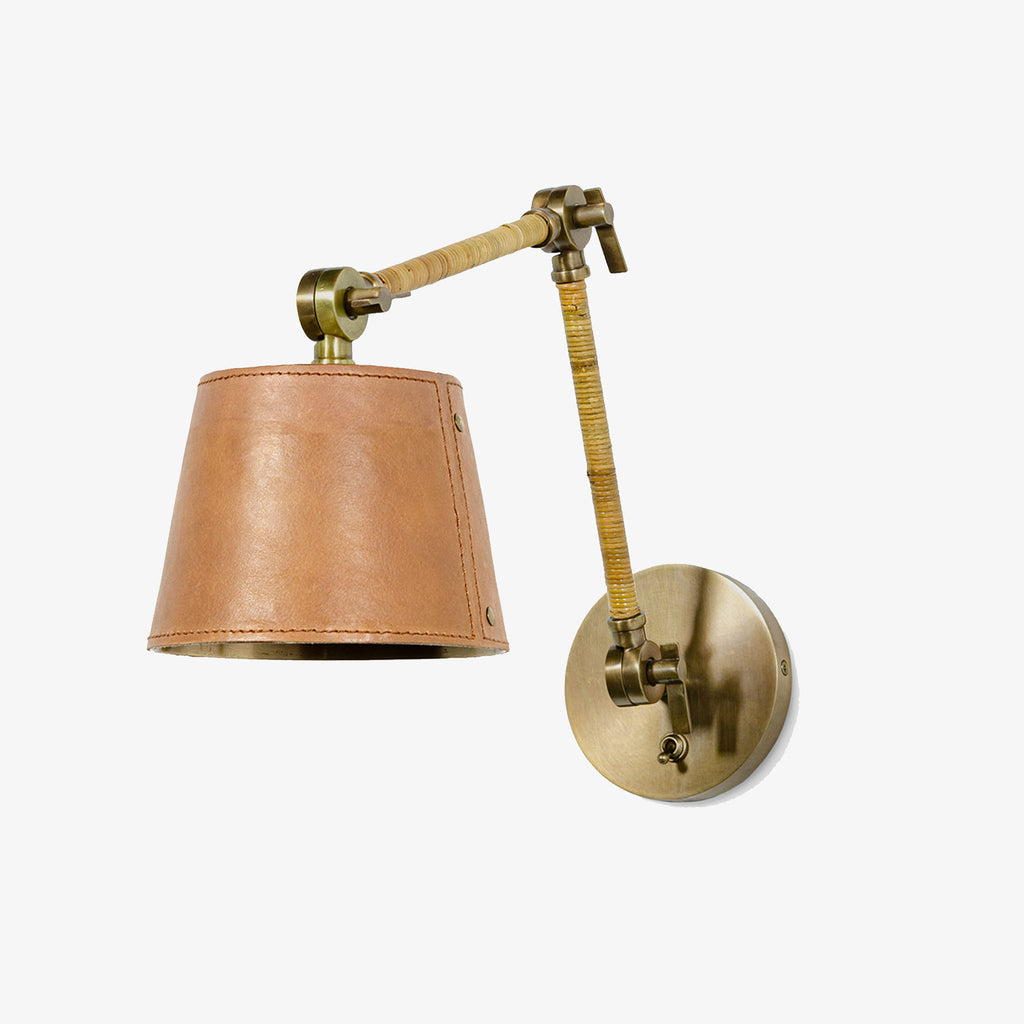 Palecek Hendrick Articulating Sconce with leather shade and brass arm on a white background