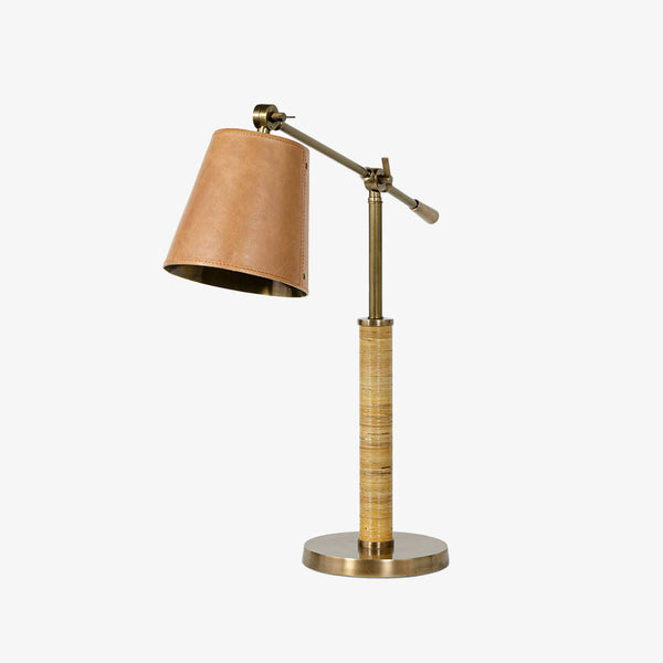 Palecek Hendrick Task Lamp with leather shade and rattan wrapped brass base on a white background