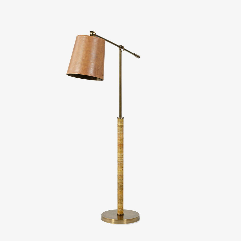 Palecek Hendrick Floor Lamp with leather shade and brass wrapped in rattan on a white background