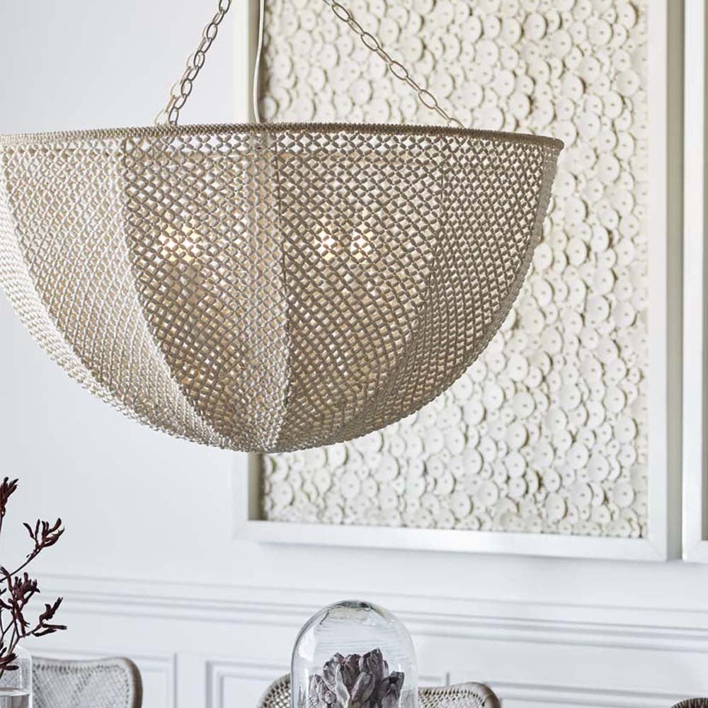 Palecek Quinn Chandelier with Ivory wood and coco beads hanging above a dining table