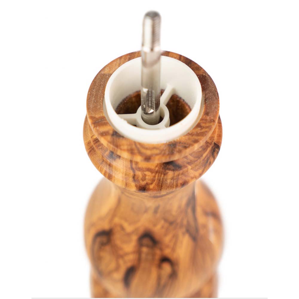 Close up of interior of Peugeot Paris brand olive wood salt mill on a white background