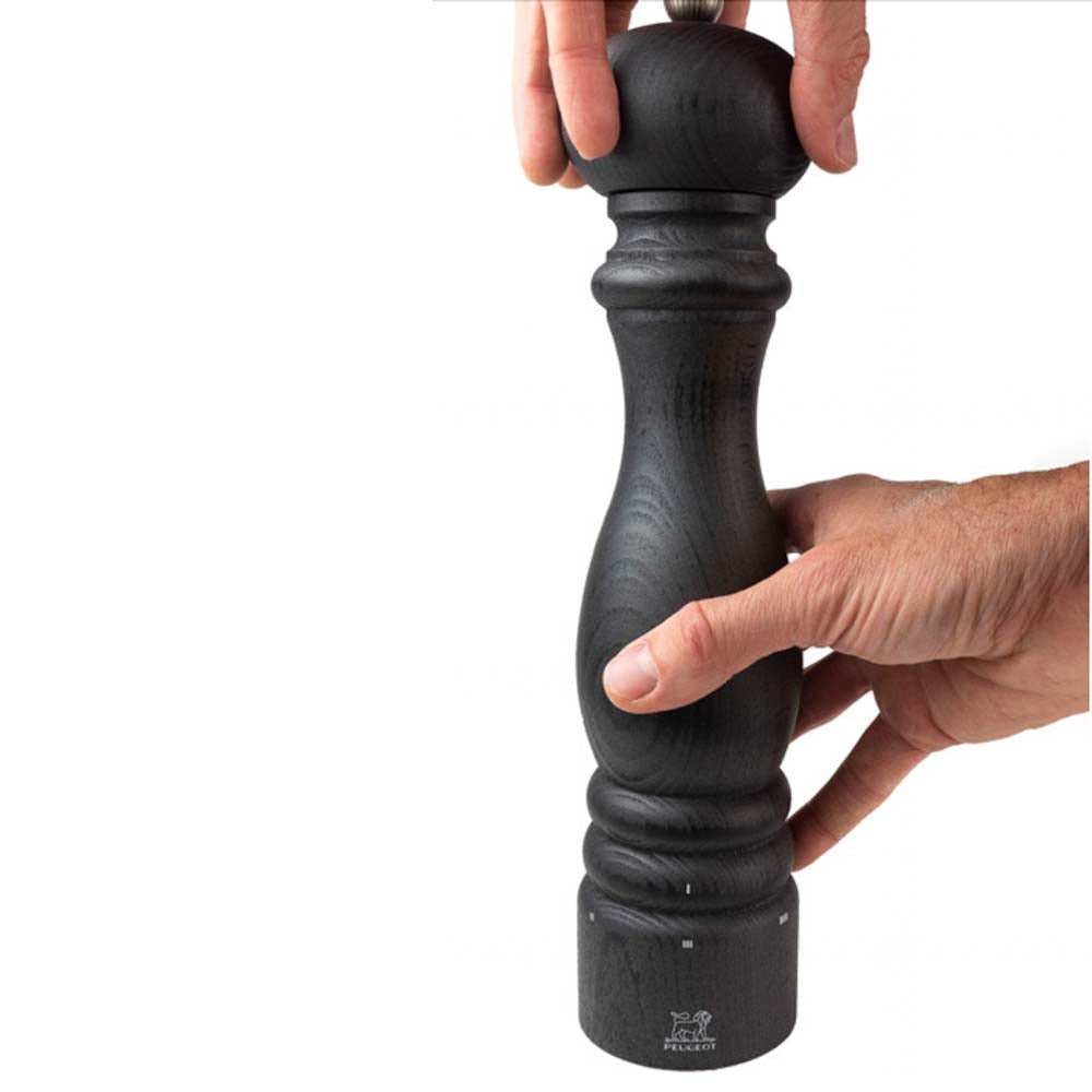 Hands turning Peugeot Paris brand U-select graphite 30cm pepper mill on white background