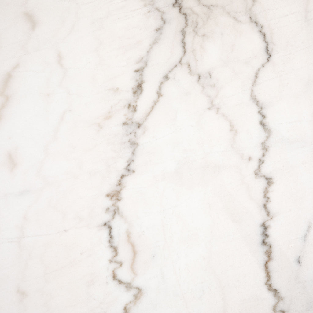 Close up of marble on Four hands brand Powell dining table with black tulip base and white marble top