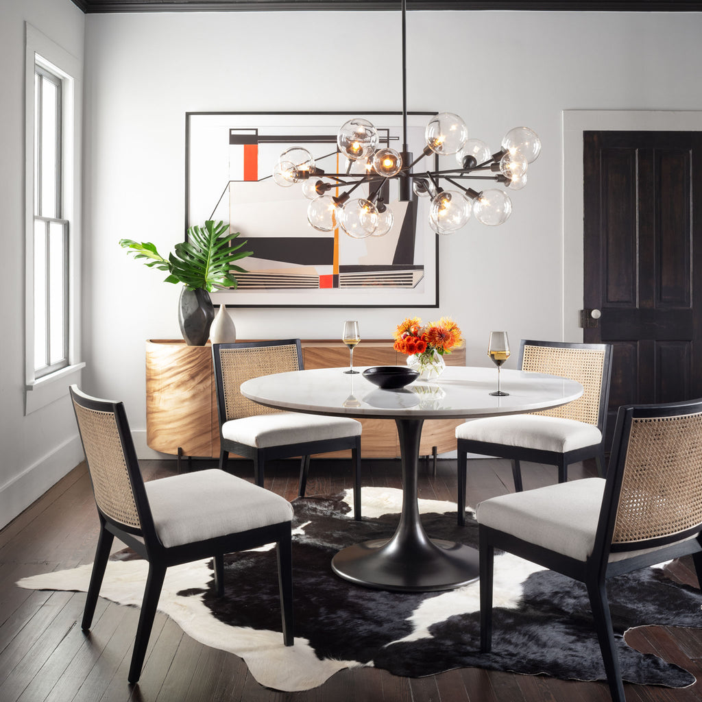 Dining room with cowhide rug and Four hands brand Powell dining table with black tulip base and white marble top