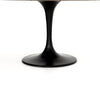 Close up of base on Four hands brand Powell dining table with black tulip base and white marble top