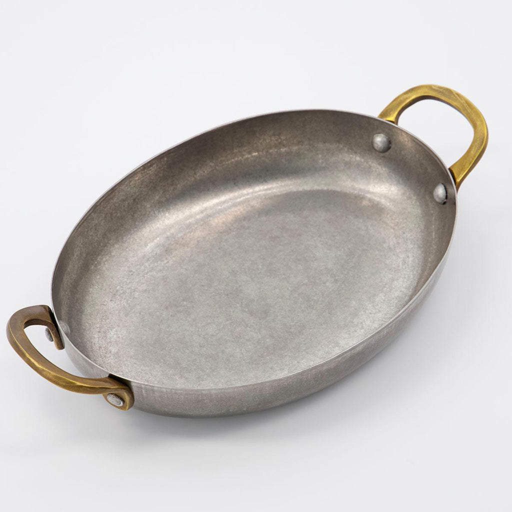 Nicolas Vahé brand metal presentation pan with brass handles on a white background