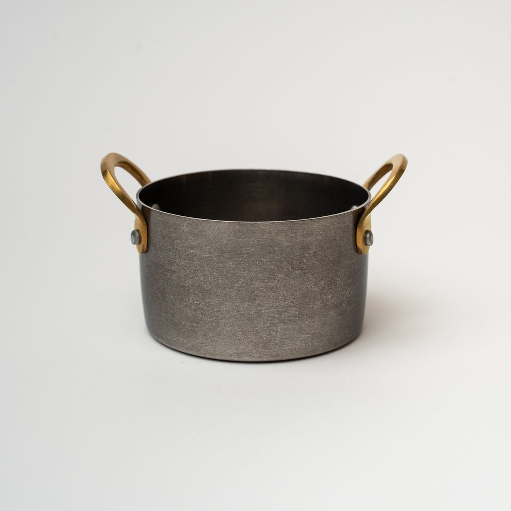 Nicolas Vahé brand metal presentation pot with brass handles on a white background