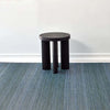 Chilewich quill woven floor mat in a room with white walls and black stool
