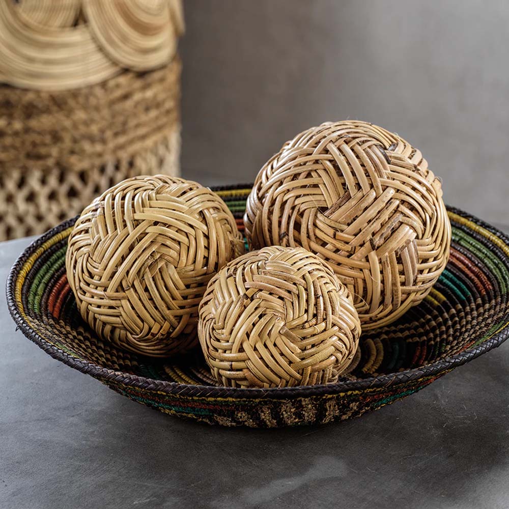 Bowl with rattan decorative orbs on a black surface