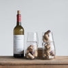 Recycled glass stemless wine glasses filled with corks on a wood surface