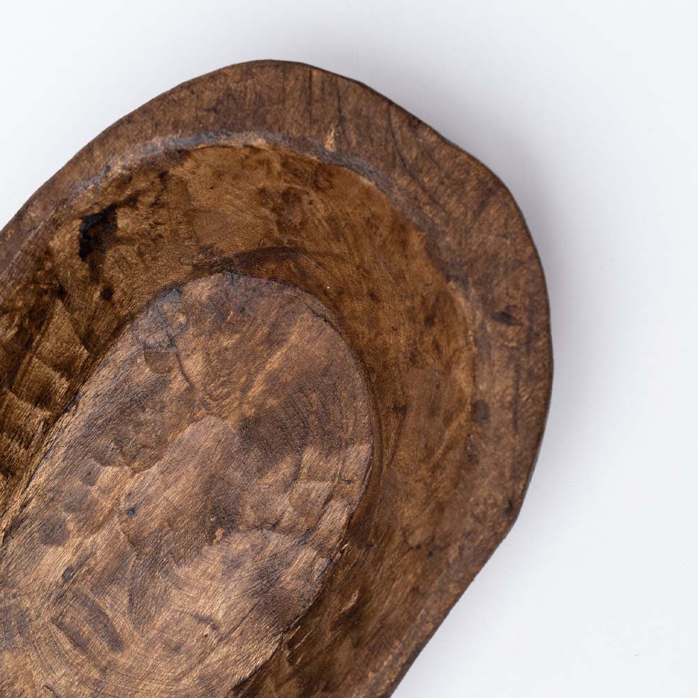 Small rough carved wood bowl on a white background