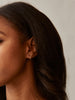 Able brand Celine Huggie Hoops in 14 carat gold fill on woman with dark hair