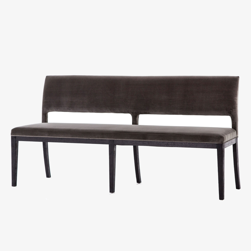 Four hands furniture brand washed velvet dining bench with grey fabric seat and dark wood legs on a white background