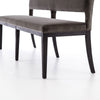 Close up of seat on Four hands furniture brand washed velvet dining bench with grey fabric seat and dark wood legs on a white background