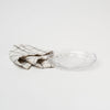Pressed glass appetizer plate with scallop edge on a white background with linen towel