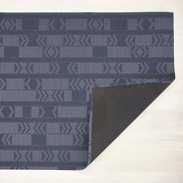 Chilwich scout woven floor mat in navy blue on a light wood floor 