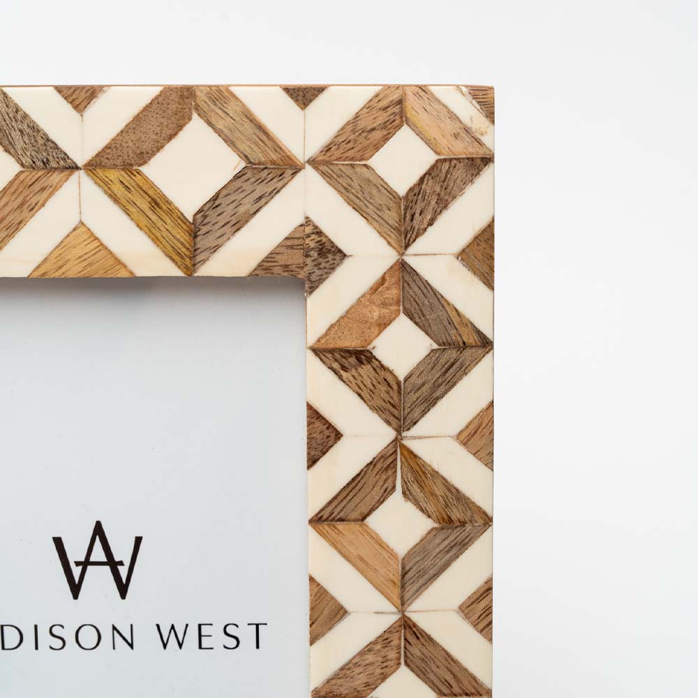 Close up of Brown wood and ivory resin geometric patterned 4x 6 picture frame on a white background