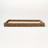 Rectangular seagrass tray with cut out handles and with linen surface on a white background