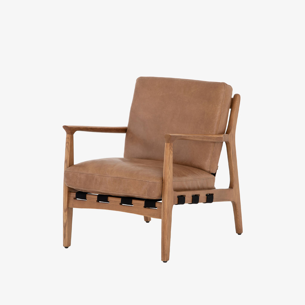Four hands brand Silas arm chair with wood frame and patina copper leather cushions on a white background