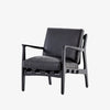 Four hands brand Silas arm chair with black wood frame and black leather cushions on a white background