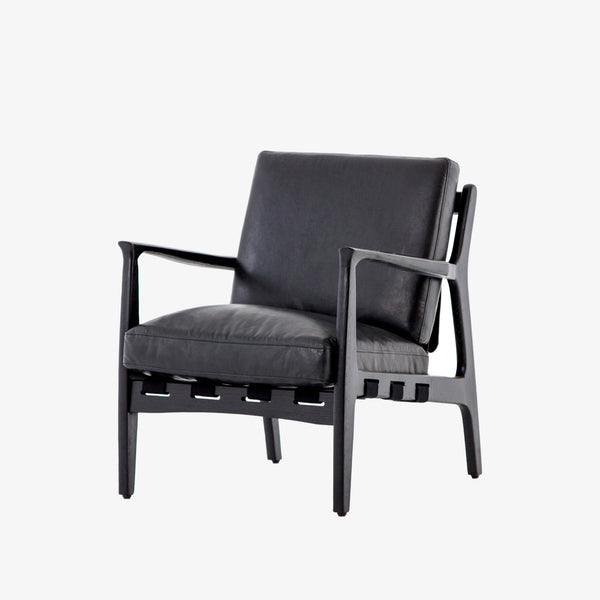 Four hands brand Silas arm chair with black wood frame and black leather cushions on a white background