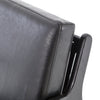 Four hands brand Silas arm chair with black wood frame and black leather cushions on a white background
