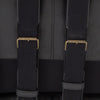 Back strapping on Four hands brand Silas arm chair with black wood frame and black leather cushions on a white background