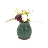Small blue ceramic vase with flowers on a white background