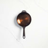 Smithey eight inch cast iron skillet on a white background