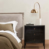 Bedroom with upholstered headboard and Black three drawer 'Soto' nightstand by four hands furniture 