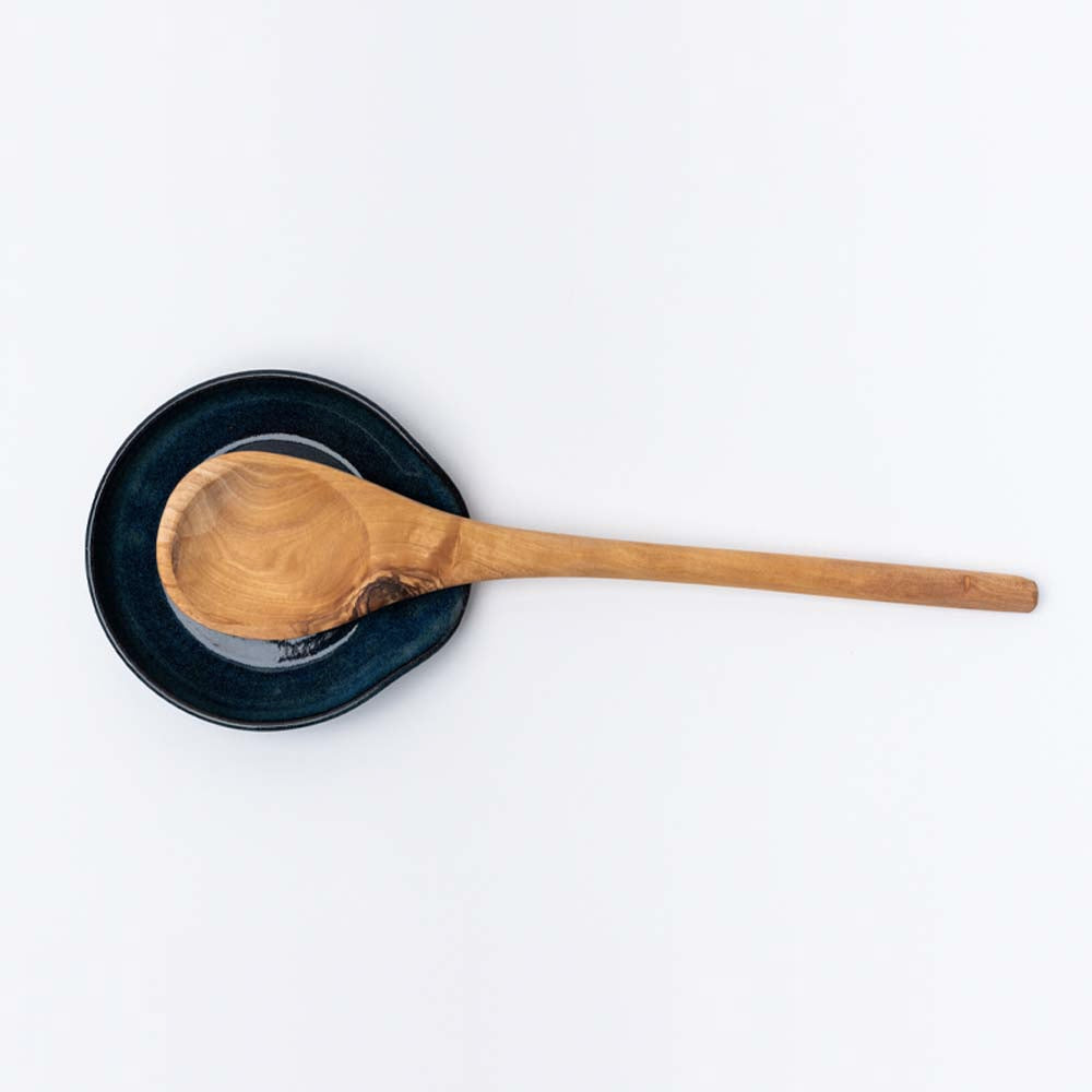 Indigo handmade in Vermont spoon rest with olive wood spoon on a white background