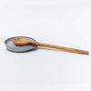 White handmade in Vermont spoon rest with olive wood spoon on a white background