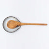 White handmade in Vermont spoon rest with olive wood spoon on a white background