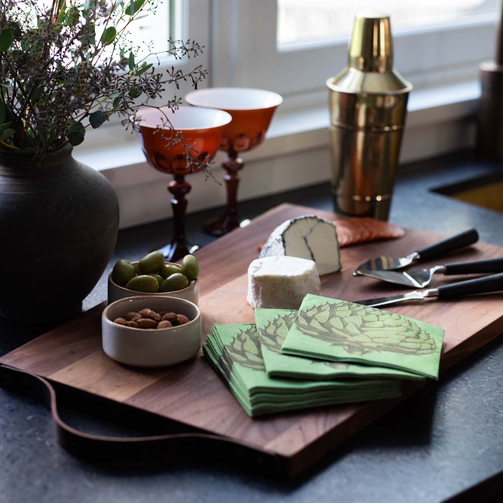 Stainless steel cheese knife set with black wood handles on a wood board wire cheese and nuts 