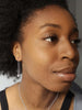 Model wearing Scream Pretty brand starburst threader earrings in silver