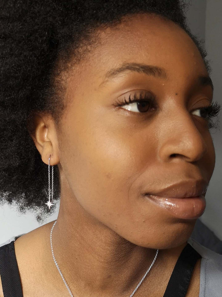 Model wearing Scream Pretty brand starburst threader earrings in silver