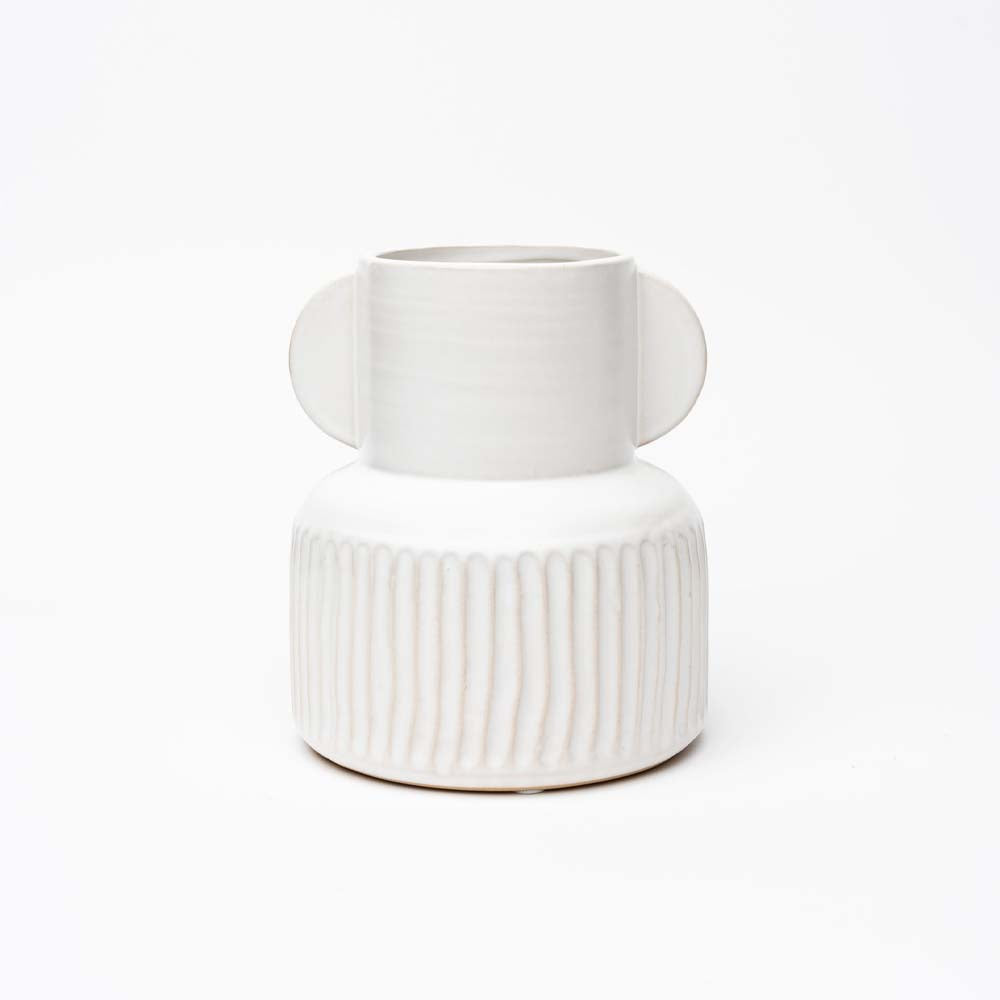 White vase with fluted base and winged top on a white background