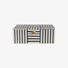 Black and white block stripe box with gold knob on lid on a white background