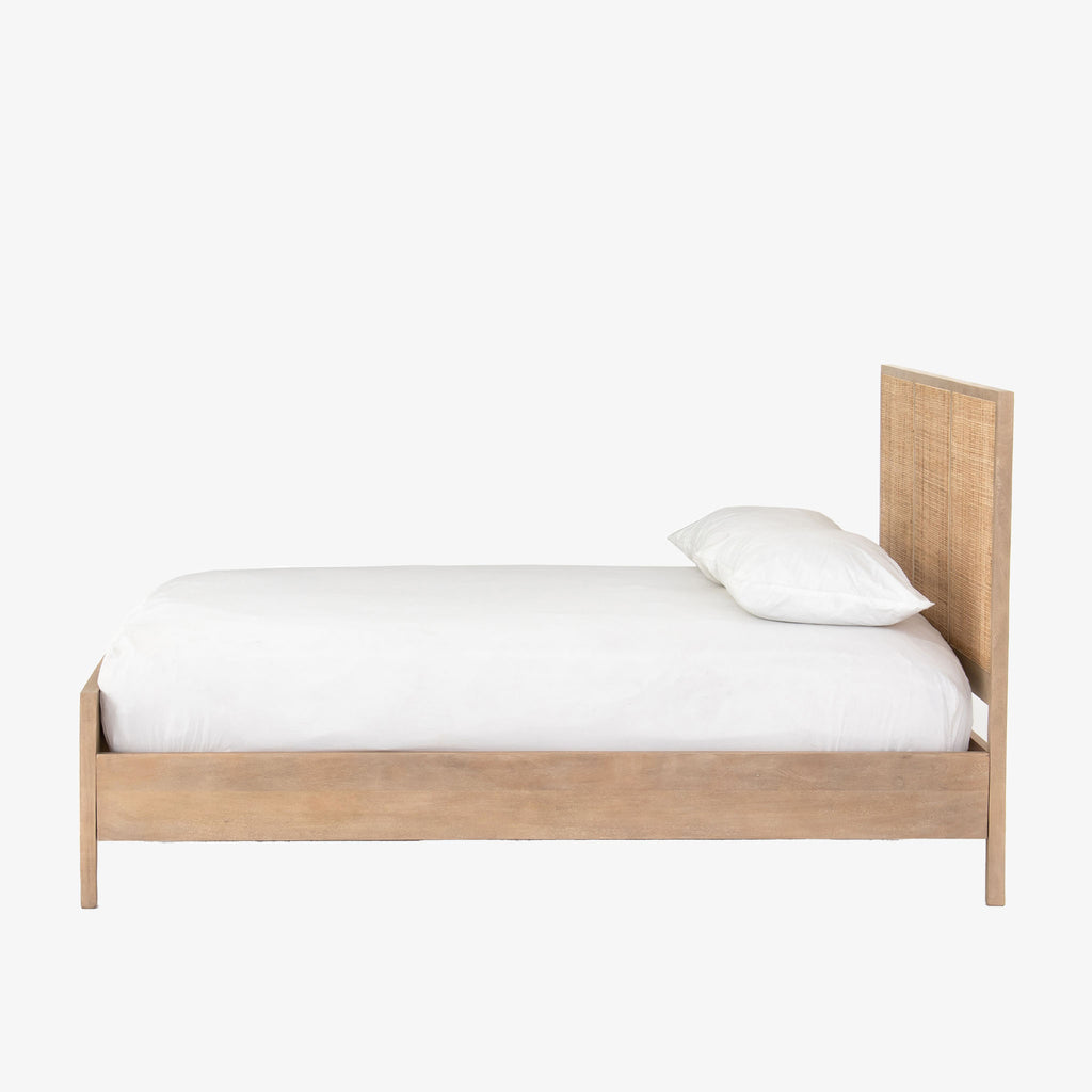 Natural wood and cane 'Sydney' bed by Four hands furniture on a white background