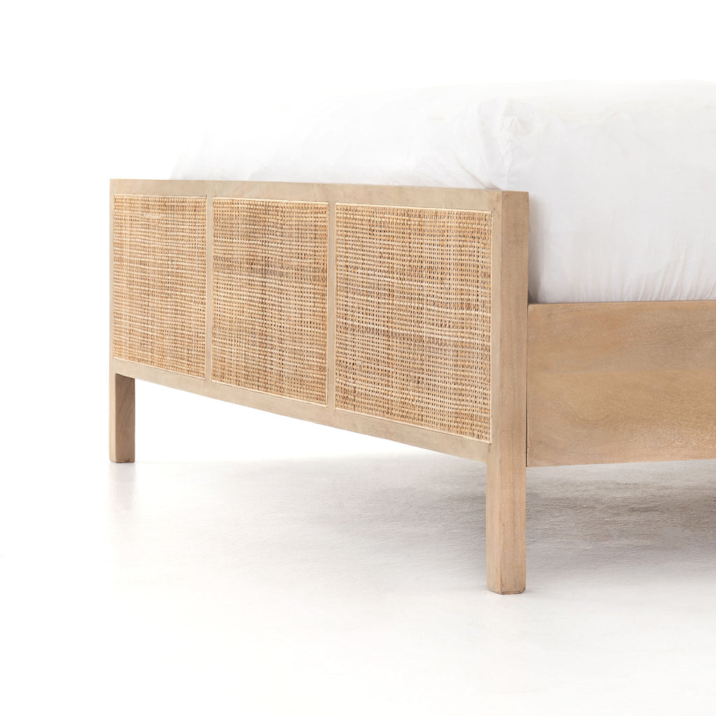 Natural wood and cane 'Sydney' bed by Four hands furniture on a white background