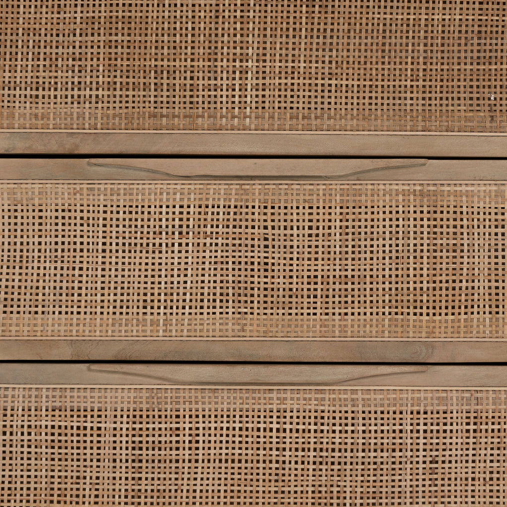 Close up of 'Sydney' Six drawer dresser by Four Hands Furniture with cane drawer fronts and mango wood pulls with black stained mango wood exterior on a white background