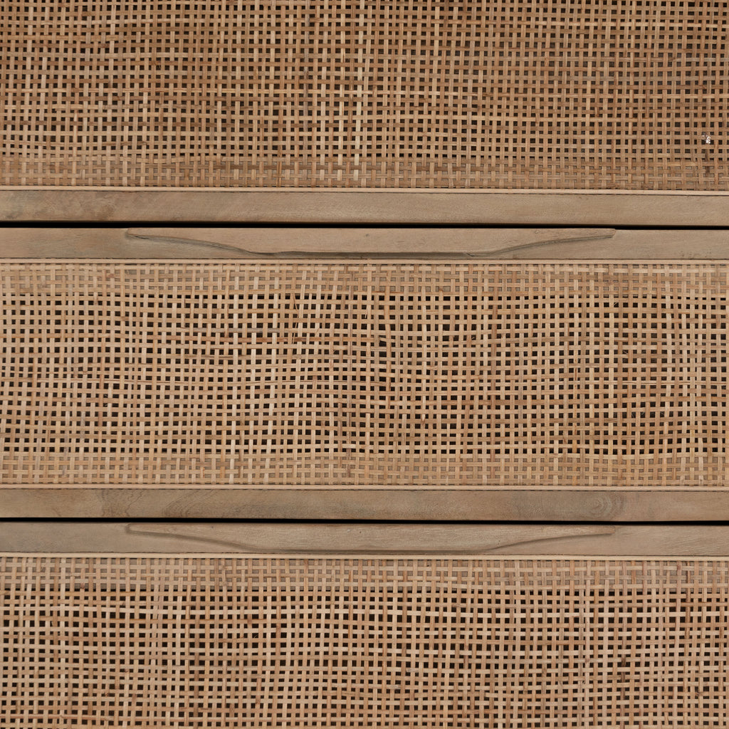 Close up of 'Sydney' Six drawer dresser by Four Hands Furniture with cane drawer fronts and mango wood pulls with black stained mango wood exterior on a white background