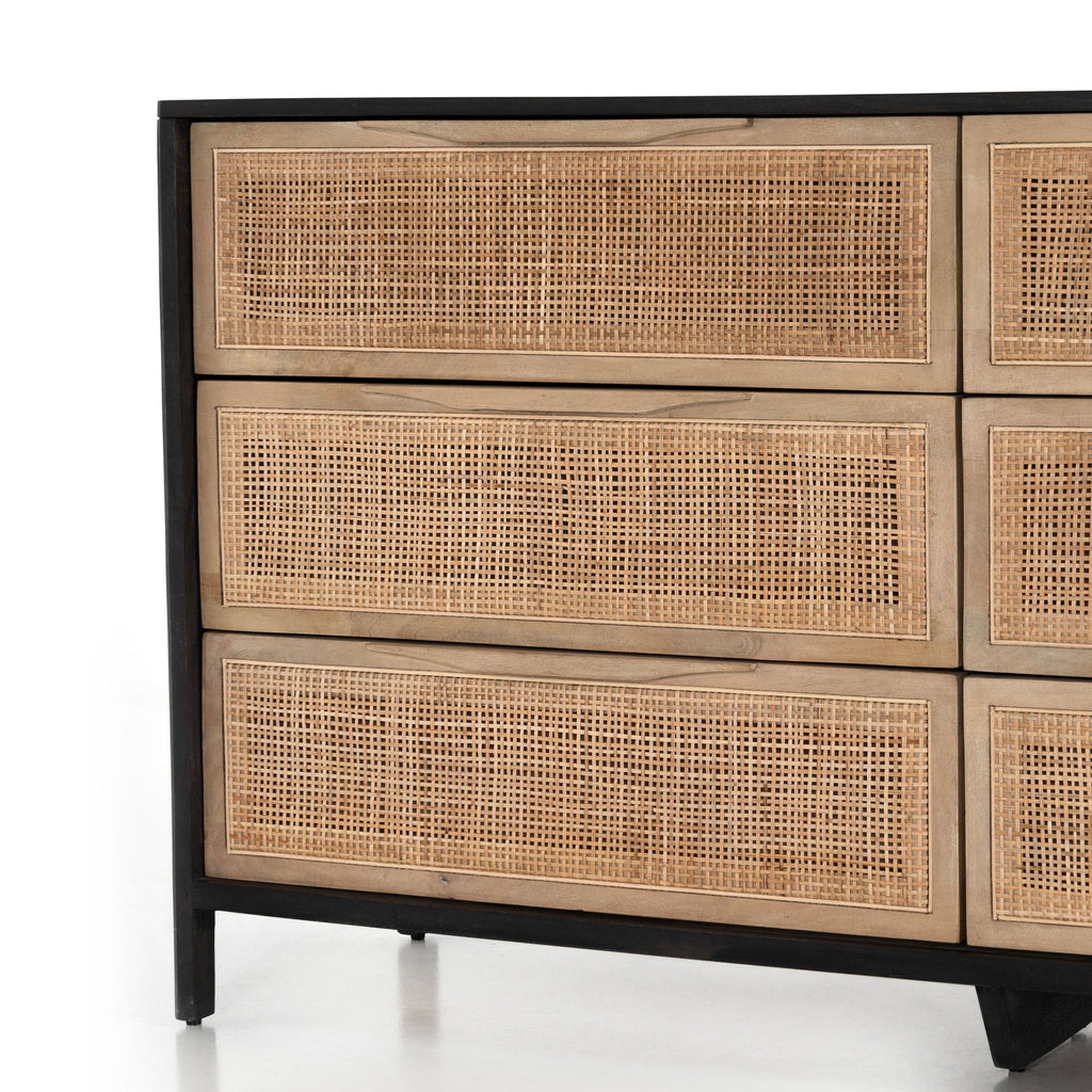 Close up of 'Sydney' Six drawer dresser by Four Hands Furniture with cane drawer fronts and mango wood pulls with black stained mango wood exterior on a white background